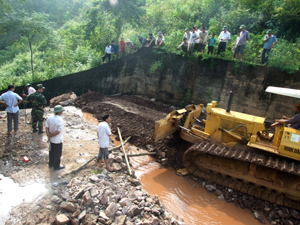 Huyện Tân Lạc và ngành chức năng huy động nhân lực, thiết bị  hạ đường tràn thoát nước xử lý sự cố hồ Vưng, xã Đông Lai.